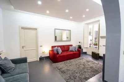 a living room with a red couch and a rug at White Style Gambero in Rome