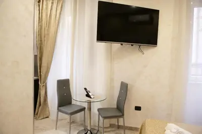 a table with two chairs and a television on a wall at Jadore Monic in Rome