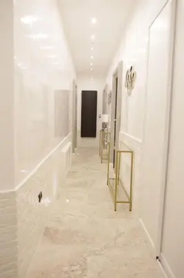 a hallway with white walls and a table and a mirror at Jadore Monic in Rome