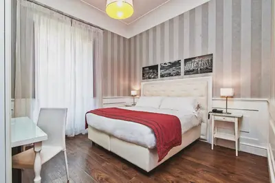 a bedroom with a large bed and a table and a desk at Star Vatican Rooms in Rome