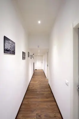 a hallway with white walls and a wooden floor at Star Vatican Rooms in Rome