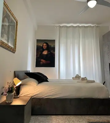 a bedroom with a large bed and a portrait of a woman at Candelor House - Apartment & Garden in Gianicolense in Rome