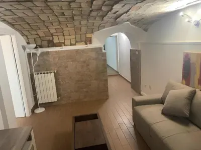 a living room with a couch and a brick wall at DOLCEVITA PONTE MILVIO in Rome