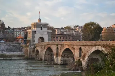 a bridge over a river with a city in the background at DOLCEVITA PONTE MILVIO in Rome