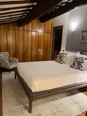a bed in a bedroom with a wooden wall at Rooftop SUITE - FORO ROMANO LUX in Rome