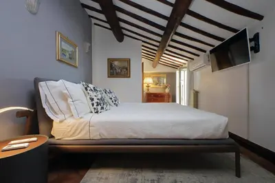 a bedroom with a white bed and a tv at Rooftop SUITE - FORO ROMANO LUX in Rome