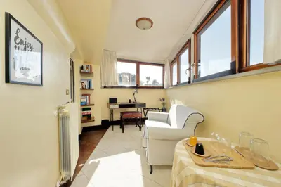 a living room with a chair and a table at Rooftop SUITE - FORO ROMANO LUX in Rome