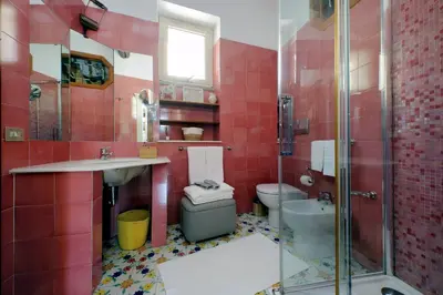 a red bathroom with a sink and a toilet at Rooftop SUITE - FORO ROMANO LUX in Rome