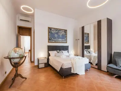 a bedroom with a bed and a chair and a mirror at The Best Rent - Three-bedroom apartment near the Quirinale in Rome