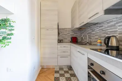 a kitchen with white cabinets and a sink at Charming Vatican Apartment in Rome