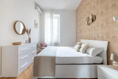 a white bedroom with a bed and a mirror at Charming Vatican Apartment in Rome