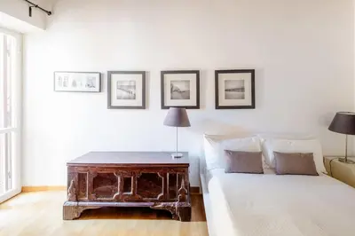 a white bedroom with a bed with a wooden table at Domus Paolina in Rome