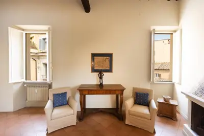 a room with two chairs and a wooden table and two windows at Amazing Fontana di Trevi in Rome