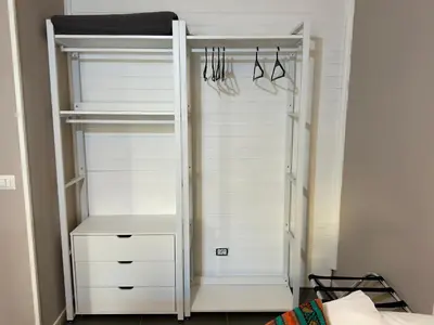 a closet with white doors and hangers at Le Due Civette Roma in Rome