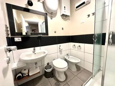 a bathroom with a sink and a toilet and a mirror at Le Due Civette Roma in Rome