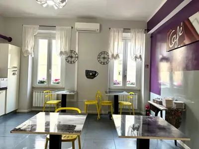 a dining room with yellow chairs and tables and windows at Le Due Civette Roma in Rome