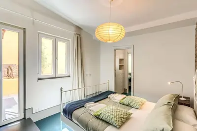 a bedroom with a bed and a large window at Trastevere 2 bdr orto botanico with private patio in Rome