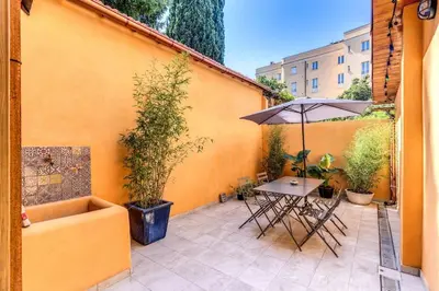 a patio with a table and an umbrella at Trastevere 2 bdr orto botanico with private patio in Rome