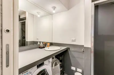 a bathroom with a washer and dryer under a sink at Trastevere 2 bdr orto botanico with private patio in Rome