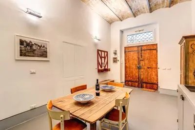 a dining room with a wooden table and chairs at Trastevere 2 bdr orto botanico with private patio in Rome