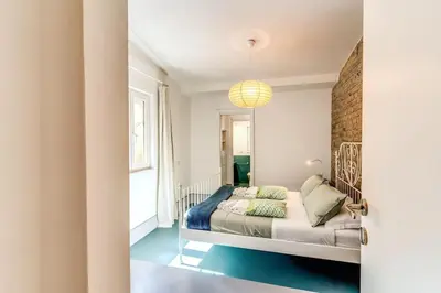 a bedroom with a bed and a brick wall at Trastevere 2 bdr orto botanico with private patio in Rome