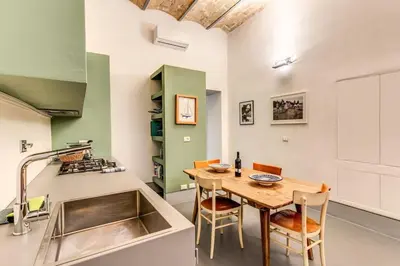 a kitchen with a table and chairs and a sink at Trastevere 2 bdr orto botanico with private patio in Rome