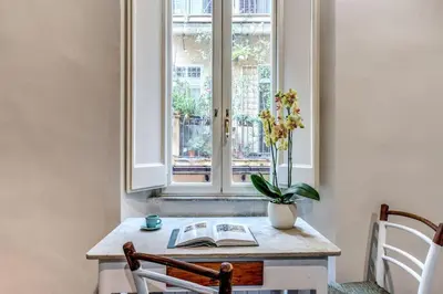 a table with a book and a window at Vicolo leopardo suite Trastevere in Rome