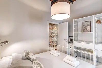 a white bedroom with a bed and a mirror at Vicolo leopardo suite Trastevere in Rome