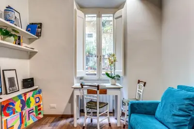 a living room with a blue couch and a table at Vicolo leopardo suite Trastevere in Rome