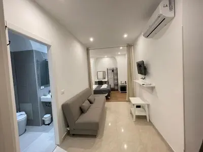 a living room with a couch and a bathroom at The Room 15 in Rome