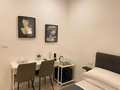a room with a table and a bed and a desk with chairs at The Room 15 in Rome