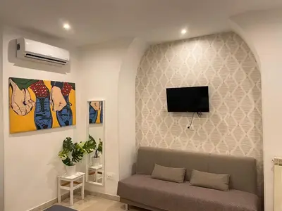 a living room with a couch and a flat screen tv on a wall at The Room 15 in Rome