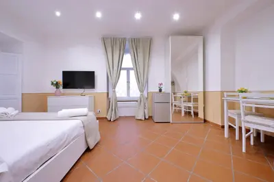 a bedroom with a bed and a television and a table at Trevi Feddy's Apartment in Rome