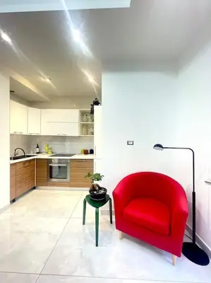a red chair and a table in a kitchen at Tiburtina Luxury Apartment in Rome