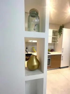 a kitchen with a large vase in a white wall at Tiburtina Luxury Apartment in Rome