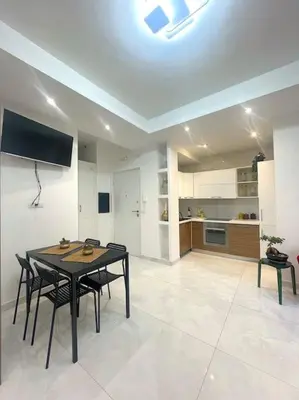 a living room with a table and chairs and a kitchen at Tiburtina Luxury Apartment in Rome