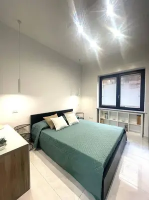a bedroom with a green bed with lights on the ceiling at Tiburtina Luxury Apartment in Rome
