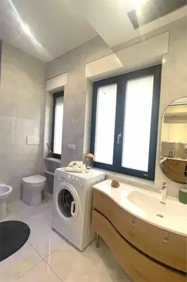 a bathroom with a washing machine and a sink at Tiburtina Luxury Apartment in Rome