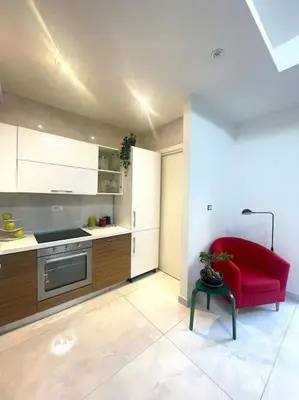 a kitchen with a red couch and a red chair at Tiburtina Luxury Apartment in Rome