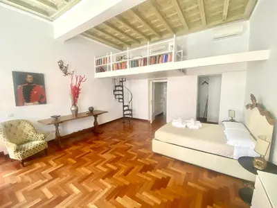 a living room with a white couch and a wooden floor at Quirinale Suite Fontane in Rome