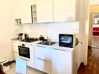 a white kitchen with a microwave and a sink at Quirinale Suite Fontane in Rome