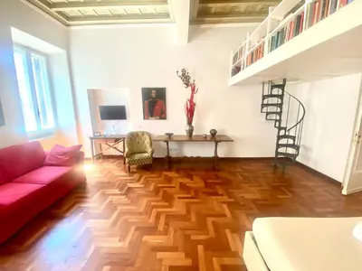 a living room with a red couch and a wooden floor at Quirinale Suite Fontane in Rome