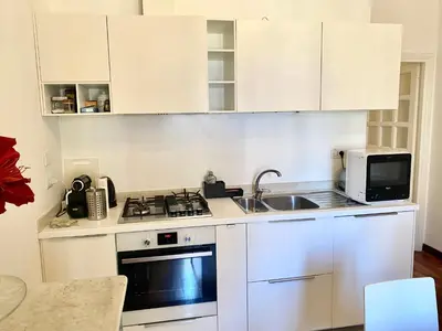 a kitchen with white cabinets and a sink and a microwave at Quirinale Suite Fontane in Rome