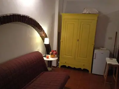 a living room with a red couch and a yellow door at Casina Roma, 2 min to Piazza Navona in Rome