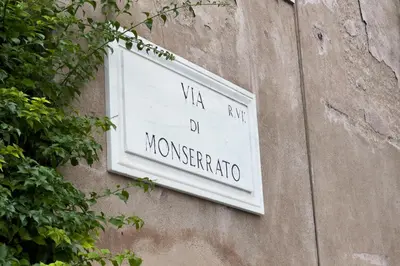 a white sign on the side of a building at Monserrato Charme Apartment - Campo dei Fiori in Rome