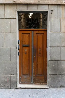 a wooden door in a brick building at Monserrato Charme Apartment - Campo dei Fiori in Rome