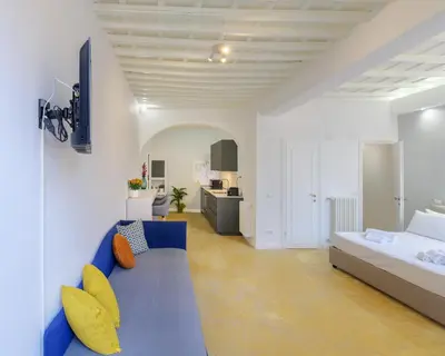 a bedroom with a blue couch and a bed at Monserrato Charme Apartment - Campo dei Fiori in Rome