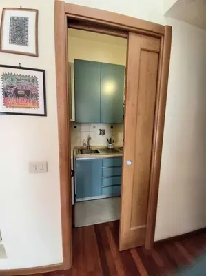 a kitchen with a door open to a kitchen with a sink at la casa del viaggiante in Rome