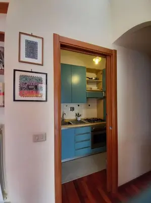 an open door to a kitchen with blue cabinets at la casa del viaggiante in Rome