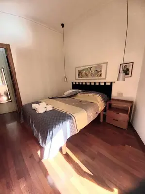 a bedroom with a large bed and a night stand at la casa del viaggiante in Rome